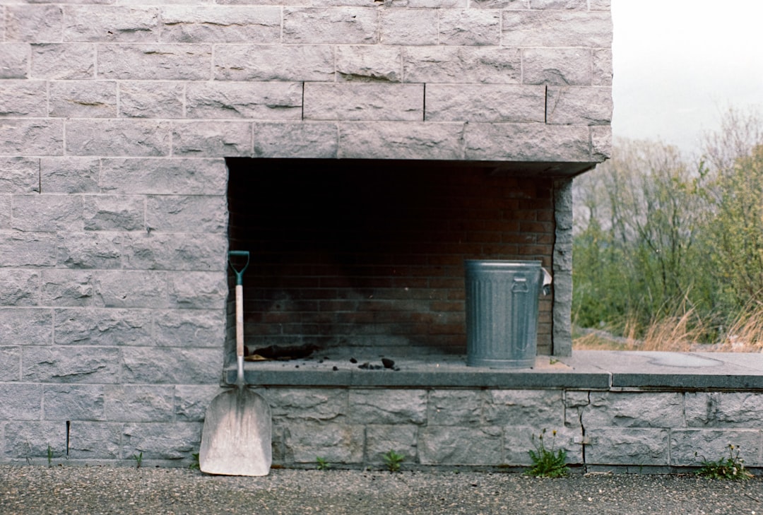 A fire place with a trash can and a trash can next to it
