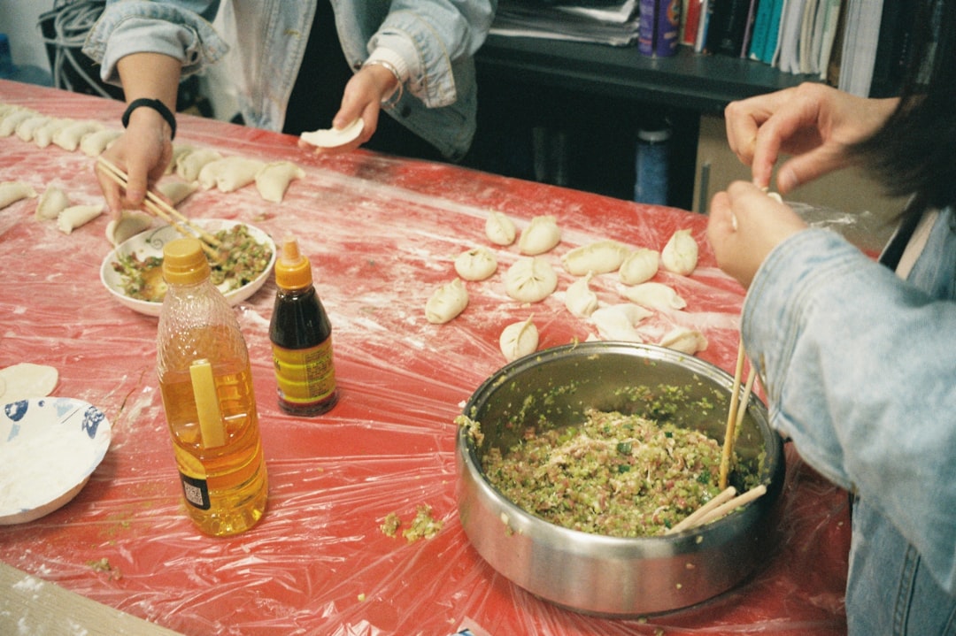 People making dumplings together at a table.