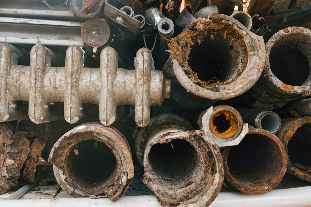 Corroded metal pipes and radiator sections piled together.
