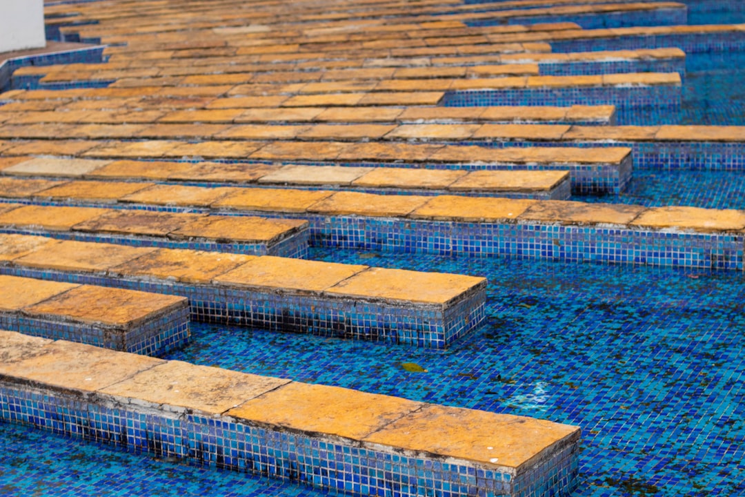 a row of blue and yellow tiles in a pool