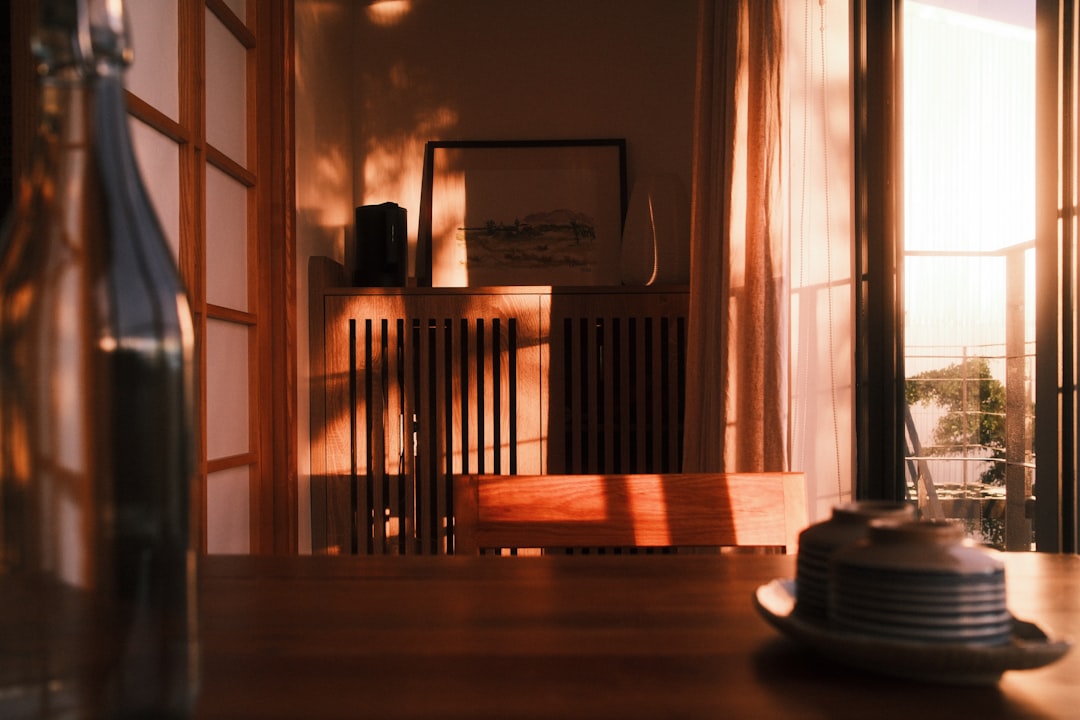 Warm sunlight streams into a dining room setting.