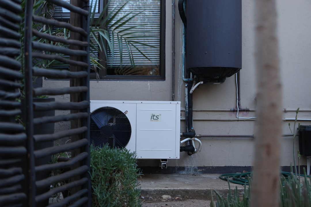 White outdoor air conditioning unit on a building wall