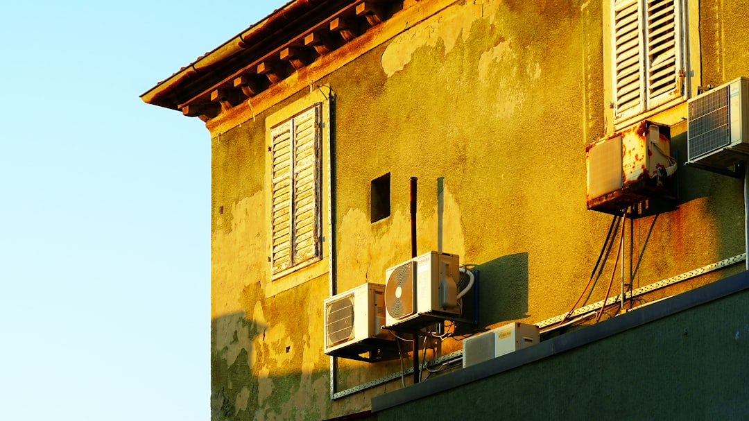 Sunlight illuminates an old building with air conditioners