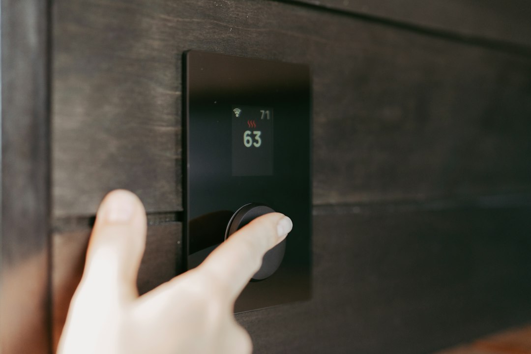 Hand adjusting a digital thermostat display