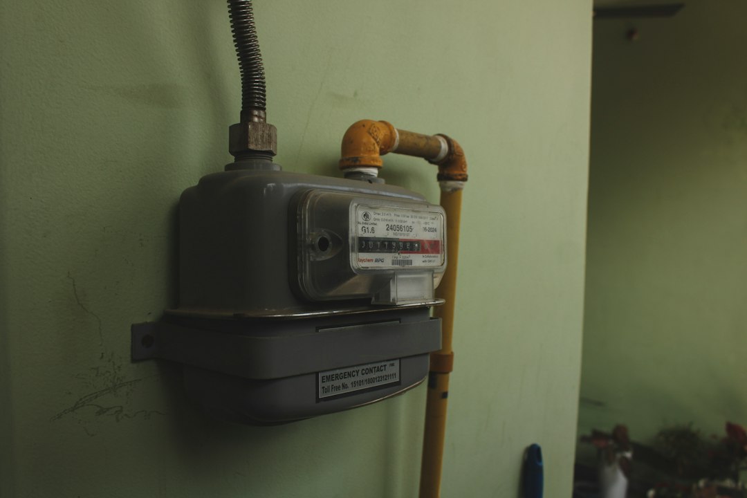 A gas meter mounted on a pale green wall
