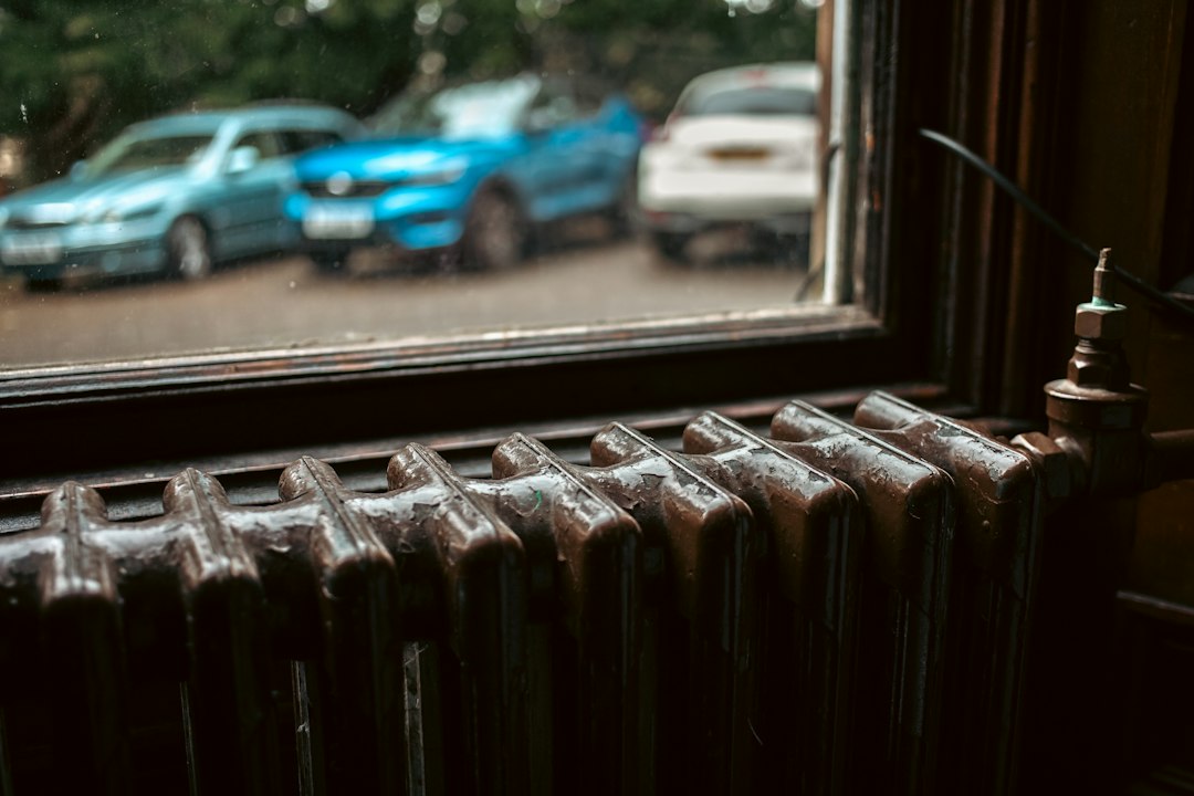 a radiator in front of a window with a view of a parking lot